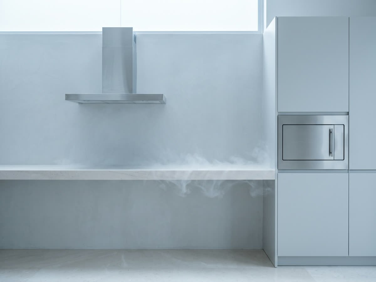 A modern kitchen counter with a microwave and a chimney